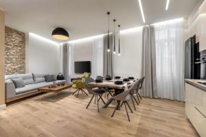 ein Esszimmer und ein Wohnzimmer mit einem Tisch und Stühlen in der Unterkunft J&A Luxury Residence in Athen