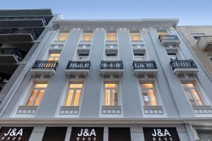 Edificio alto de color blanco con ventanas y balcones en J&A Luxury Residence, en Atenas