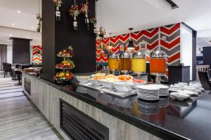 Wyndham Bogota في بوغوتا: طابور بوفيه مع اطباق من طعام ومشروبات