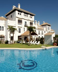 una piscina di fronte a un grande edificio di Moon Dreams El Cortijo a Matalascañas