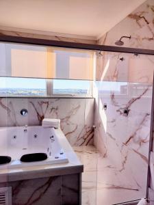 a bathroom with a sink and a shower at Hotel Itália in Paranavaí