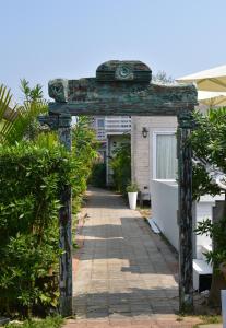 un arco di fronte a una casa con piante di Living Room Beach Resort a Morjim