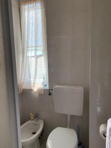 Fiumaretta di AmegliaAppartamento 8的浴室里有白色马桶和洗手池 更多4张照片
