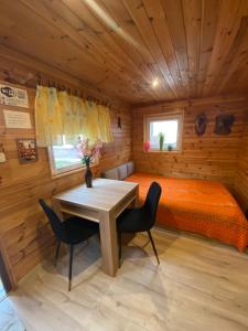 una camera da letto con un letto, un tavolo e delle sedie di Pokoje i domki nad Kanałem Bystrym a Augustów