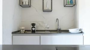 ローマにあるPgrhome Luxury Apartments Domus Pantheonの白いキャビネットとシンク付きのキッチン