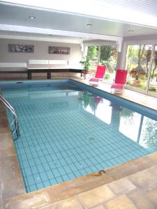 a swimming pool with two chairs and a piano at Spa Hôtel Restaurant Au Lion d'Or in La Petite-Pierre