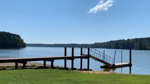 a dock on a body of water with a smoke at Alpine Lakeview Motel Room WiFi,Sandy beach Boat Ramp,Pier,Marina,Bath House with Laundromat in Hemphill