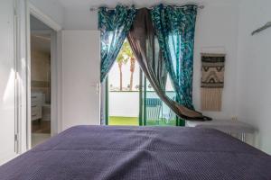 ein Schlafzimmer mit einem lila Bett und einem Fenster in der Unterkunft Deluxe Duplex Bungalow Private Parking in Maspalomas