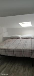 Bett in einem weißen Zimmer mit Fenster in der Unterkunft Casa vacanza Sant O,rsola in Bergamo