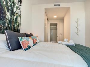 ein Schlafzimmer mit einem großen weißen Bett mit Kissen in der Unterkunft Los Flamencos Vista Playa - 6209 in Playa Paraiso