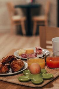 a table with two plates of food and two glasses of juice at Garden Hotel Rennes Centre Gare in Rennes