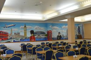 een eetkamer met tafels en stoelen en een muurschildering aan de muur bij Viking Hotel in Londen