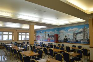 a dining room with tables and chairs and a mural at Viking Hotel in London