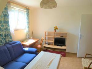Una sala de estar con un sofá azul y un televisor en Bauernhof Obersulm-Eschenau Schwäb.Toskana, en Obersulm