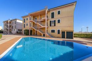 a villa with a swimming pool in front of a building at Apartment Corb Mari in Port de Pollensa
