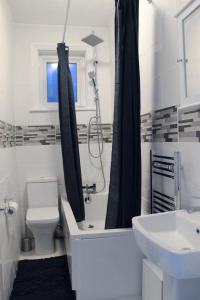 a bathroom with a tub and a toilet and a sink at 2 bed 1st floor Apartment-own entrance & parking in Portsmouth