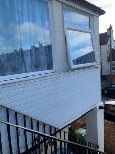 a house with a balcony with a window at 2 bed 1st floor Apartment-own entrance & parking in Portsmouth