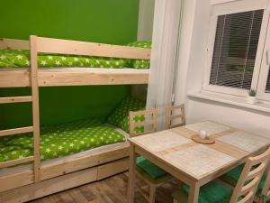 een kamer met een tafel en een stapelbed en een tafel en stoel bij Apartmán Nikolka in Lipno nad Vltavou