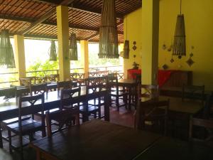 um restaurante com mesas e cadeiras de madeira numa sala em Sitio da Calma em Gamela