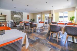a restaurant with tables and chairs in a room at Camping maeva Escapades Le Colomba in Olmeto