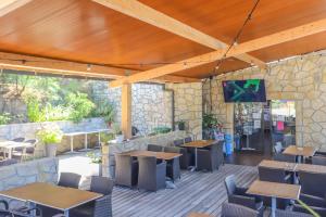 a restaurant with tables and chairs and a tv on the wall at Camping maeva Escapades Le Colomba in Olmeto