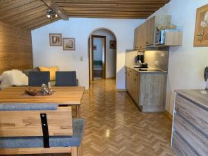 a living room with a table and a kitchen at Haus Hermi in Nesselwängle