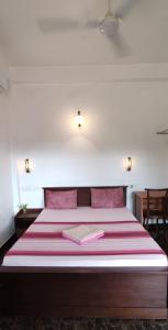 een slaapkamer met een bed met een rode en witte deken bij Villa Rodrigo in Negombo