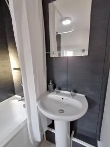 ein Badezimmer mit einem weißen Waschbecken und einem Spiegel in der Unterkunft 7 beds sleeps 9 2 miles (7 mins) from Newcastle centre in Low Team