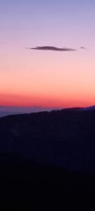 a sunset in the sky over a field at Pensiunea Royal in Ranca