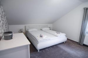 Schlafzimmer mit einem weißen Bett und einem Schreibtisch in der Unterkunft Apartma Tia in Zreče