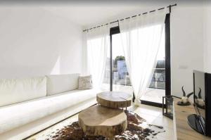 sala de estar con sofá blanco y mesa en Maravilloso apto de diseño a 1 minuto de la playa, en Cala Santandria