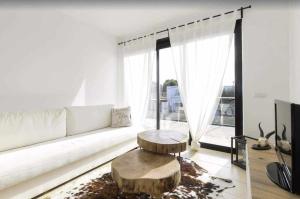 a living room with a white couch and a table at Maravilloso apto de diseño a 1 minuto de la playa in Cala Santandria