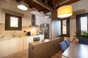 a kitchen with white cabinets and a table with blue chairs at Apartamentos Casa Roldan I in Benasque +10 photos