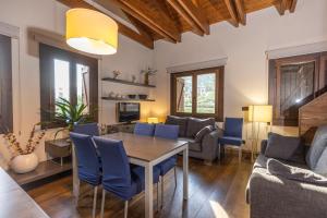a living room with a table and blue chairs at Apartamentos Casa Roldan I in Benasque