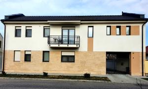 a large white building with a balcony on it at Maya Apartment in Sárvár