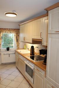 a kitchen with white cabinets and a sink and a window at Ferienwohnung Schmalzgrube in Jöhstadt