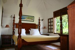 a bedroom with a bed and a window at Les Cycas in Saint-Claude