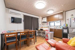 a kitchen and dining room with a table and chairs at ゲストハウスOneWorld Toji東寺 in Kyoto