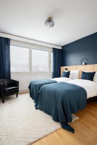 a bedroom with a large bed with blue walls at 2 Bedroom apartment with free parking in Kuopio
