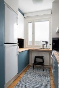 uma cozinha com electrodomésticos brancos e um tapete preto e branco em 2 Bedroom apartment with free parking em Kuopio