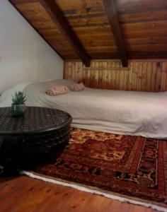 a bedroom with a bed and a table on a rug at Petradi Residence @ Agoriani-Parnassus in Eptalofos