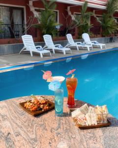 a table with food and drinks next to a swimming pool at Jasminn Hotel - AM Hotel Kollection in Betalbatim