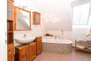 uma casa de banho com um lavatório e uma banheira em Ferienapartments Meixner em Eisenberg an der Pinka