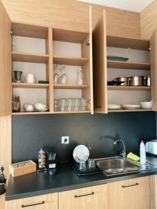 een keuken met houten kasten, een wastafel en een aanrecht bij City view in Residences in Boergas