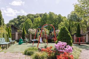 un parque infantil en un jardín con gente jugando en él en Готель Мараморош, en Shayan