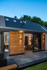 ein Haus mit einer Terrasse mit einem Holzzaun in der Unterkunft Roselea Cottage in Luss