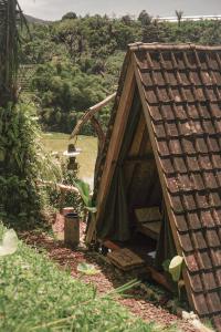a small house with a roof in a field at KAMPUNG KOPI CAMP in Pujungan