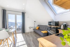 a kitchen and living room with a large window at Apartamenty 73 in Ustrzyki Dolne
