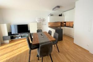 uma sala de jantar com uma mesa de madeira e cadeiras pretas em Wein Kultur Apartment Flavia Solva em Wagna