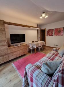 a living room with a bed and a flat screen tv at Casa Al Rin in Valdidentro